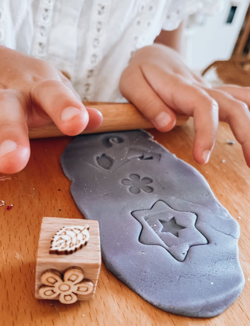 Poppy & Daisy natural playdough kit: purple playdough, star cutter, wooden stamp, roller, and bag.