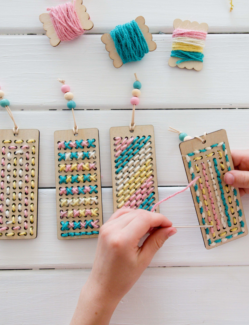 Poppy & Daisy DIY bookmark kit contents: pouch, wooden board, yarn, beads, and craft instructions.
