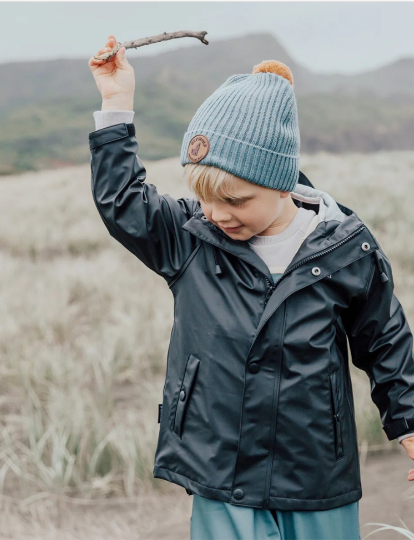 Front view of a black kids' hooded rain jacket with elastic cuffs, front pockets, and button closure.