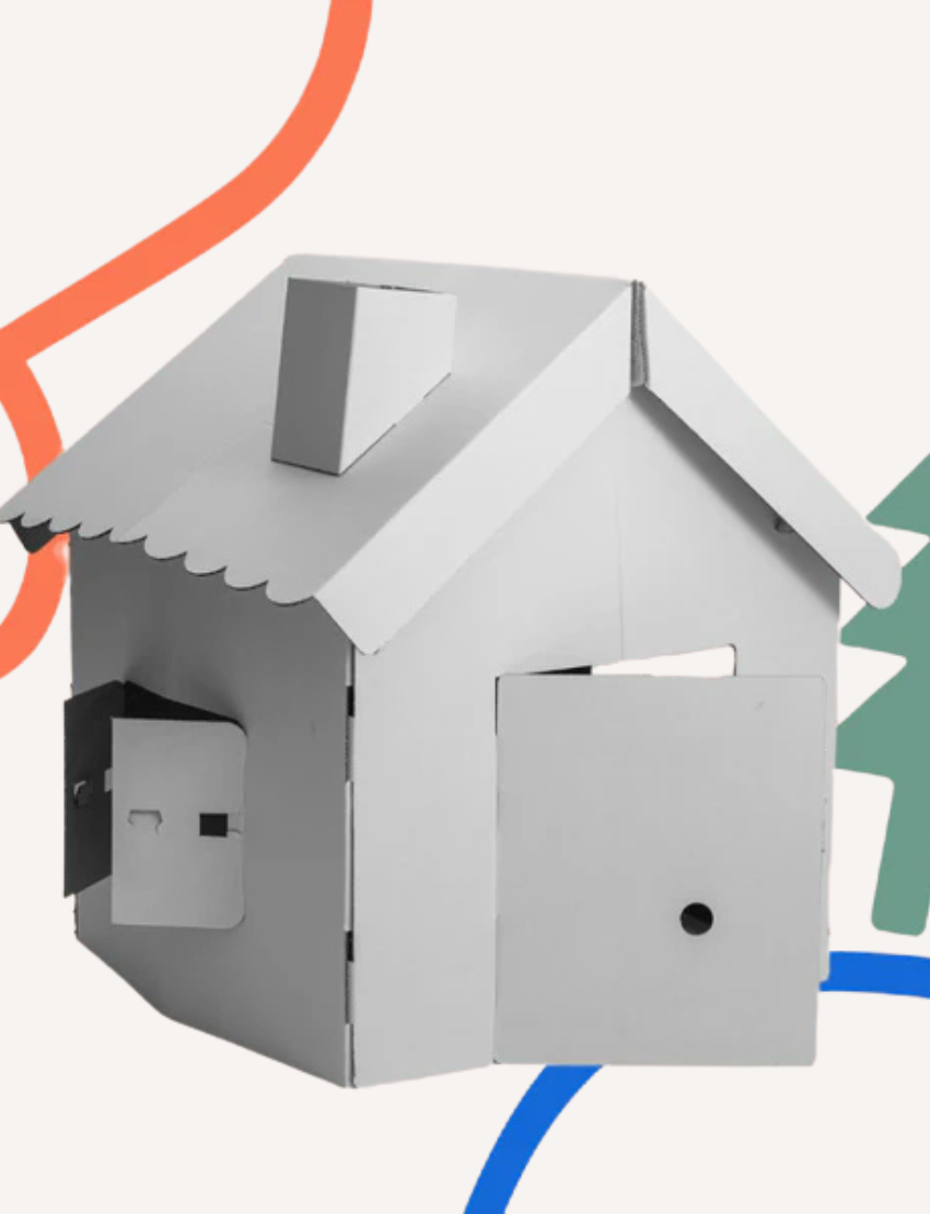 Angled view of a white scalloped cardboard playhouse for kids, perfect for sustainable, creative, and durable indoor play.