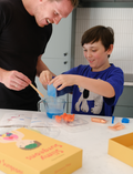Father and son enjoy the Slimy Surgeons experiment, a therapist-designed kit by Sensory Play Australia for interactive anatomy learning.