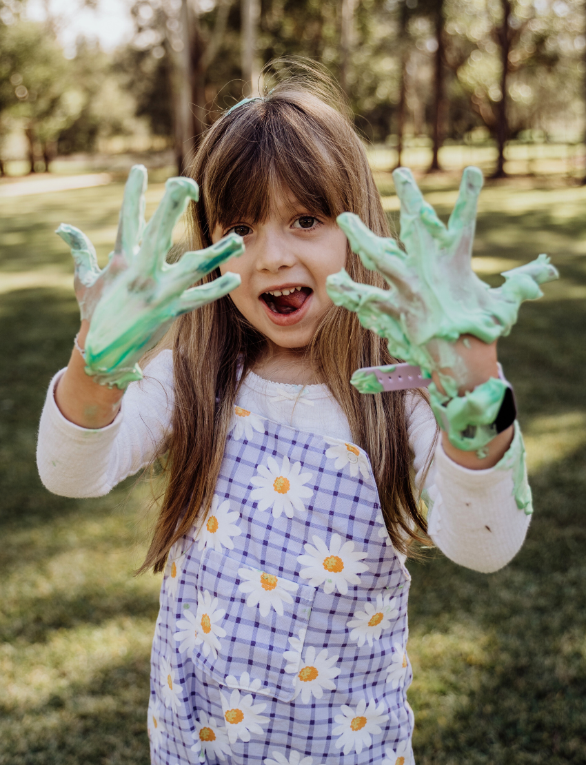 The Therapy At Home "Regulating the Nervous System through Sensory Play Program" is a large green and blue box with visible packaging. It includes sensory toys, sunscreen, snacks, slip and slide set, sprinkler mat, art supplies, and hygiene items for kids.