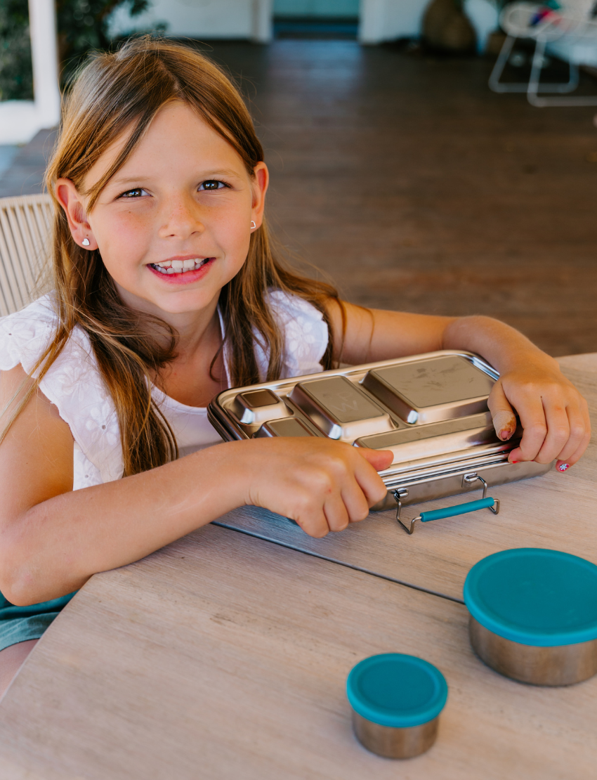 The Lunch Box Program by Therapy At Home comes in a teal and blue patterned box with stainless steel containers, a blue cup, activity cards, planners, a game, and labels—all neatly packed and partially displayed.