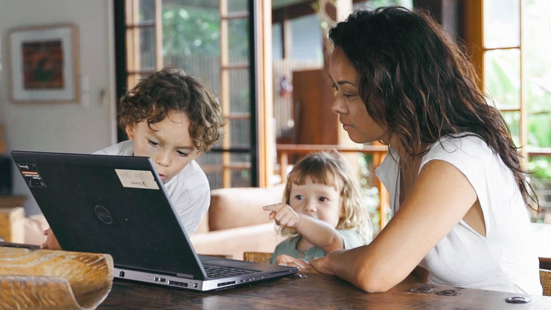 Mother and children looking at a laptop, possibly for an online masterclass.