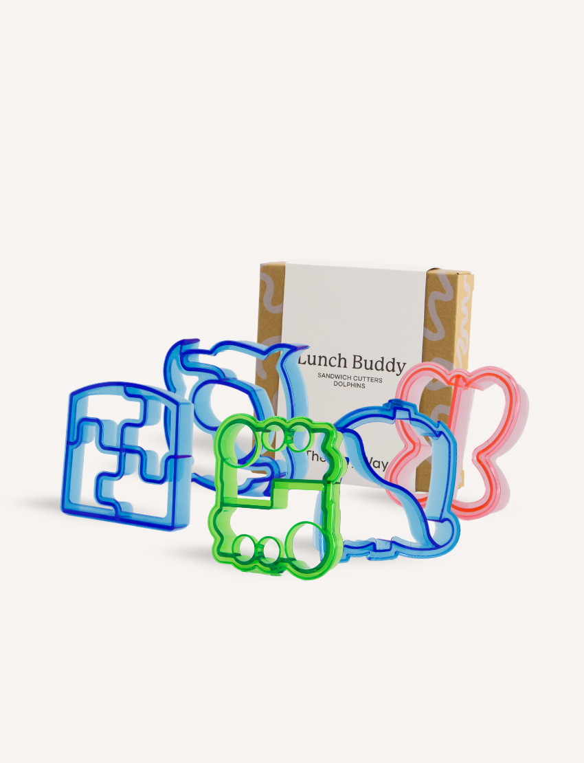 Displayed in front of a cardboard box labeled with the brand "The Play Way," the Lunch Buddy Sandwich Cutters Set features five vibrant plastic cutters in entertaining shapes, such as vehicles and animals, designed to enhance your child's mealtime experience.