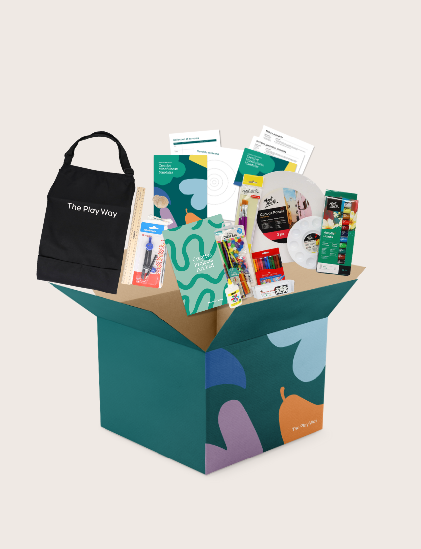 The Creative Mindfulness: Mandalas Program by Therapy At Home features a vibrant box with art supplies for kids—colored pencils, markers, paints, rulers, paper, and a "The Play Way" tote—ideal for fostering creativity and fine motor skills.