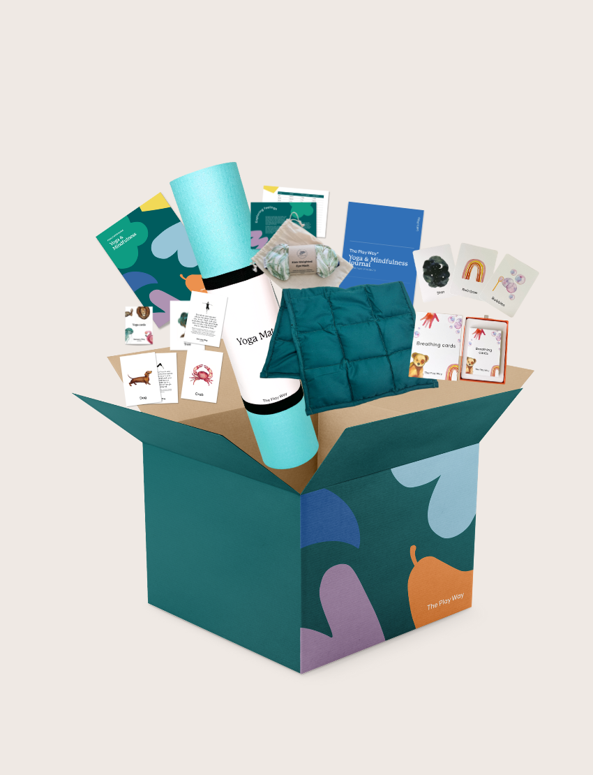 The Yoga & Mindfulness Program by Therapy At Home features an open teal box with abstract designs, holding a yoga mat, teal cushion, books, cards, and small items—perfect for home yoga and mindfulness—displayed upright against a simple background.