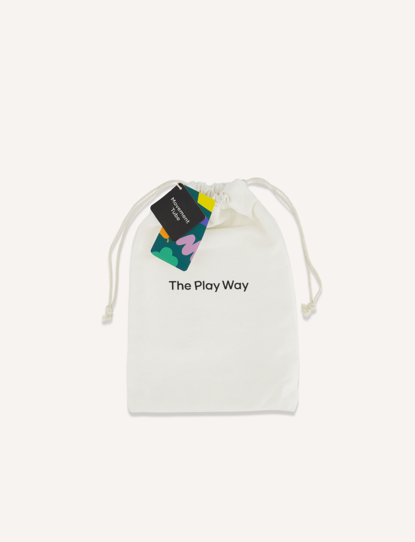 A white drawstring bag featuring the brand name "The Play Way," comes with two white cords for closing. Attached to one of the drawstrings are colorful tags with creative designs and text. Ideal for sensory regulation, this Movement Tube helps maintain emotional balance during playtime.