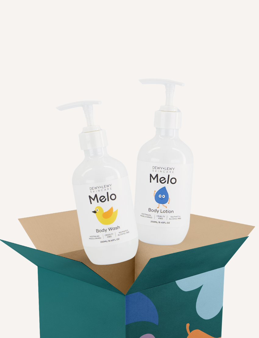 Two white pump bottles of Melo Body Wash and Lotion by Dewy+ Lewy are in an open box.