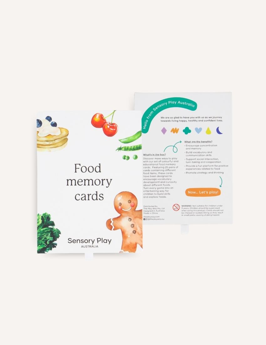 Displayed are two boxes of the "Food Memory Card Set." The larger box on the right features images of a gingerbread person, a cherry, peas, and a dessert. The smaller box on the left displays similar food graphics. Perfect for food exploration, this set is by "Sensory Play Australia.