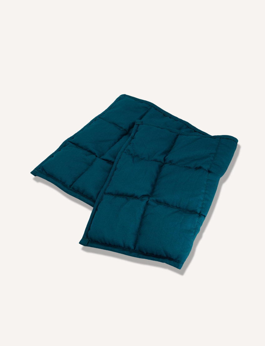 Two teal Weighted Lap Pads from The Play Way provide deep pressure and sensory input for calming relaxation at home or school.