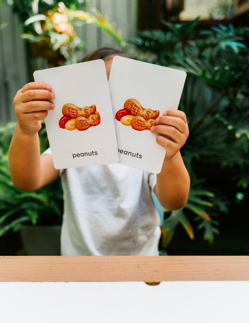 Two Sensory Play Australia "Food Memory Cards Set in Box" packages are shown. The front box displays vibrant illustrations of food items such as broccoli, a gingerbread cookie, and a pie. The back box includes instructions and game information in text and graphics, enhancing the mealtime experience through playful exploration of food.