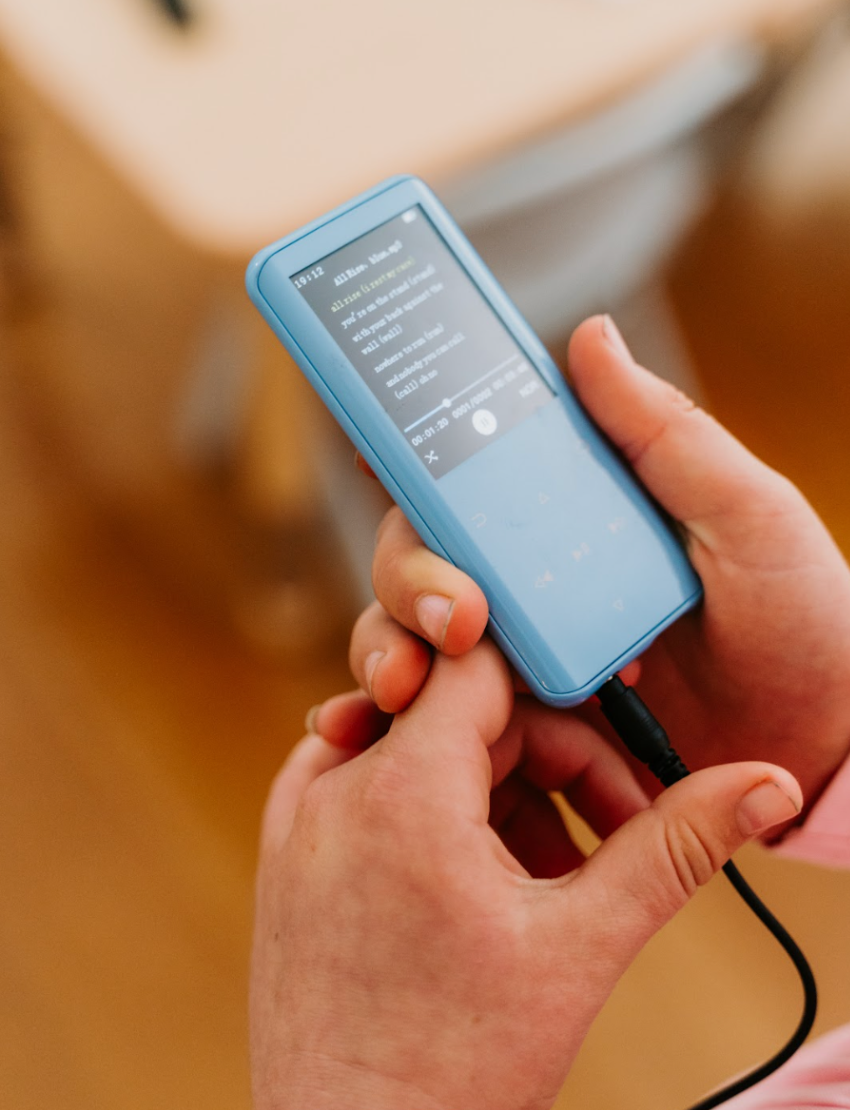 Two identical blue Sensory Play Mindful MP3 Players are displayed; one with the screen showing "Sensory Play Australia" and the other revealing the back, which bears the same text. These devices feature various control buttons below the screen and a "RESET" button on the back, making them perfect for calming meditation tracks.