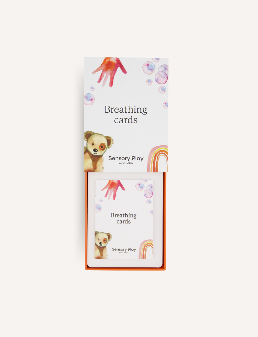 The image shows the back of a product packaging from "The Play Way." The packaging includes a welcoming message, a list of benefits, and product safety information for the Regulation Card Set Bundle. The text is set against a white background with colorful icons at the top.