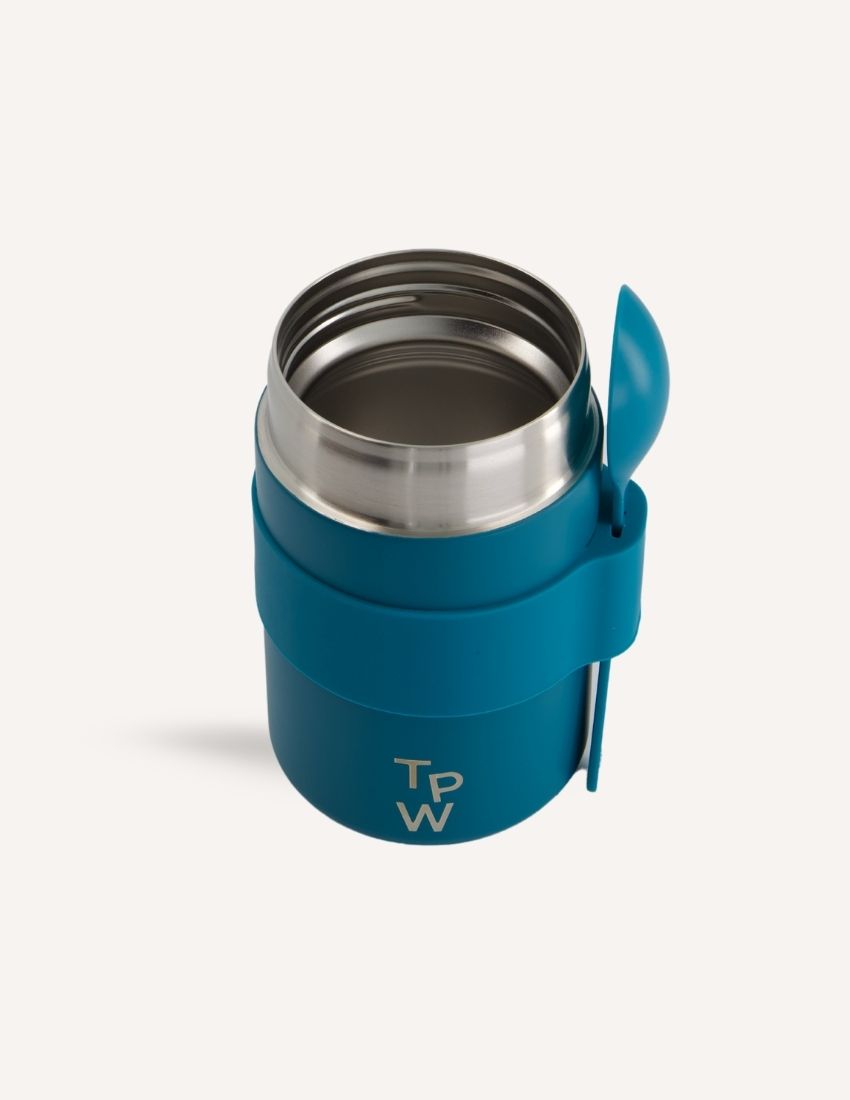 A blue insulated food jar from The Play Way with the initials "T P W" printed on the front. The Lunch Buddy Insulated Container Set features a matching blue silicone band around its midsection that holds a blue spoon, along with a leak-proof lid. The background is plain white.