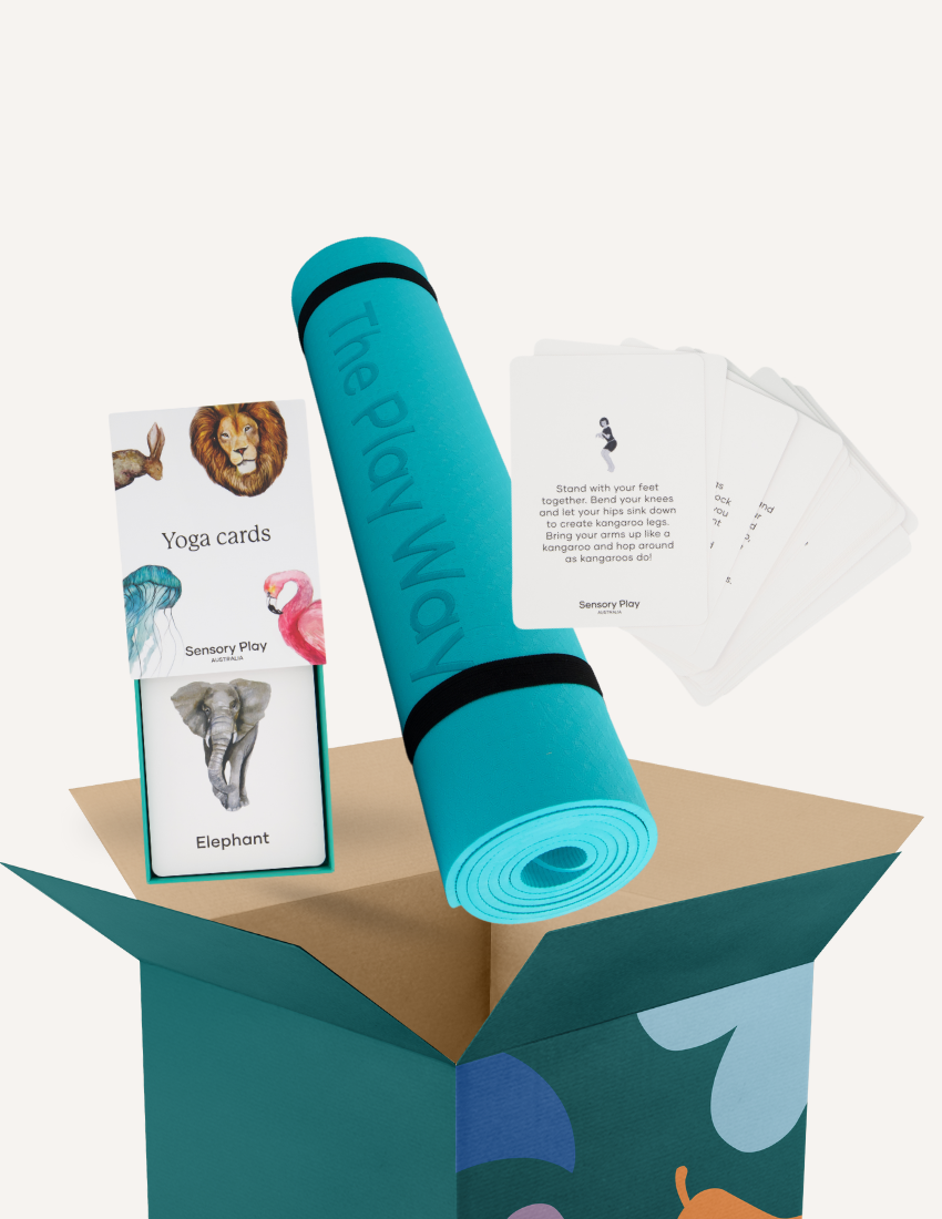 The image shows "Yoga Mat and Cards" by The Play Way, featuring an open box with a teal mat that has a black strap, a Yoga Card Set with animals like lion and elephant, mindfulness text cards, all in a box decorated with colorful abstract shapes.