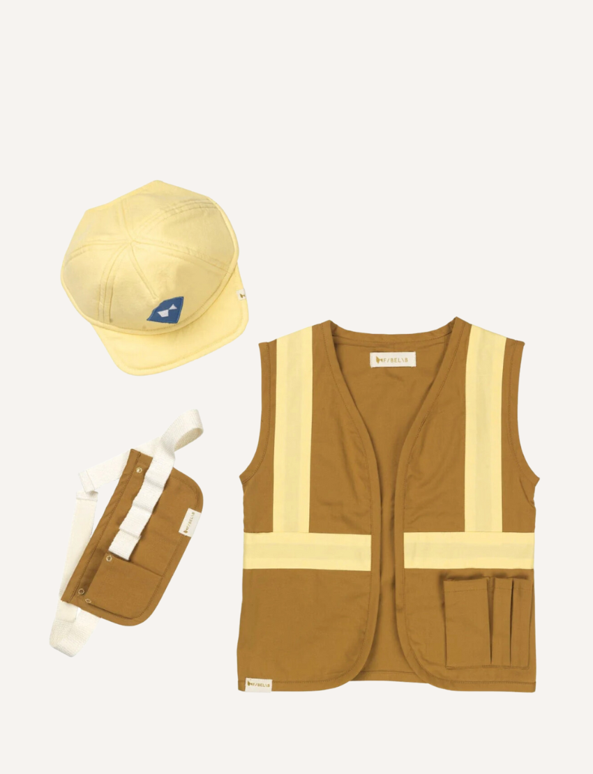 The Dress Up - Builder (3-6yrs) set by Fabelab includes a yellow construction-themed outfit for children, consisting of a vest with reflective stripes, a matching cap adorned with a triangular logo, and a small utility belt complete with a pouch, all displayed on a plain background.