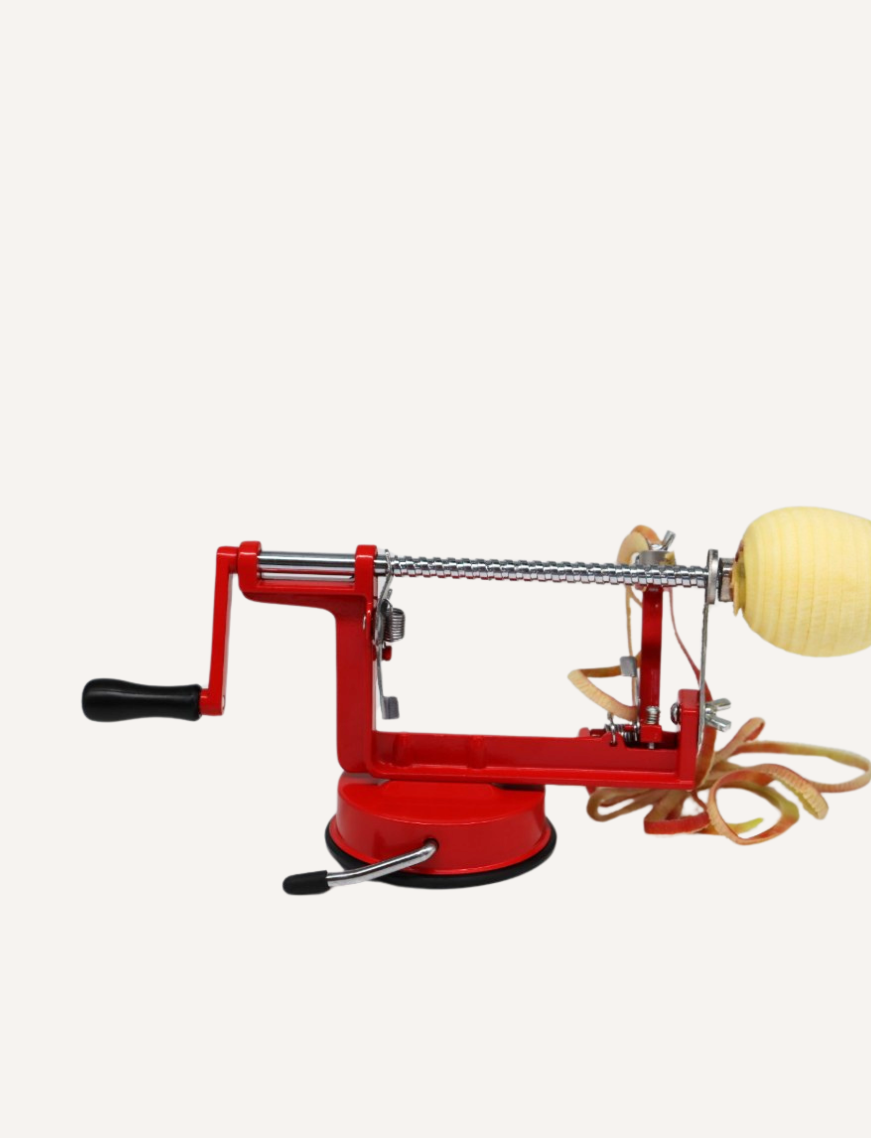 An Apple Slinky by The Play Way, featuring a red and silver design with a black handle, isolated on a white background. This device includes a crank, prongs to hold an apple, and a spring-loaded stainless steel blade mechanism for peeling.