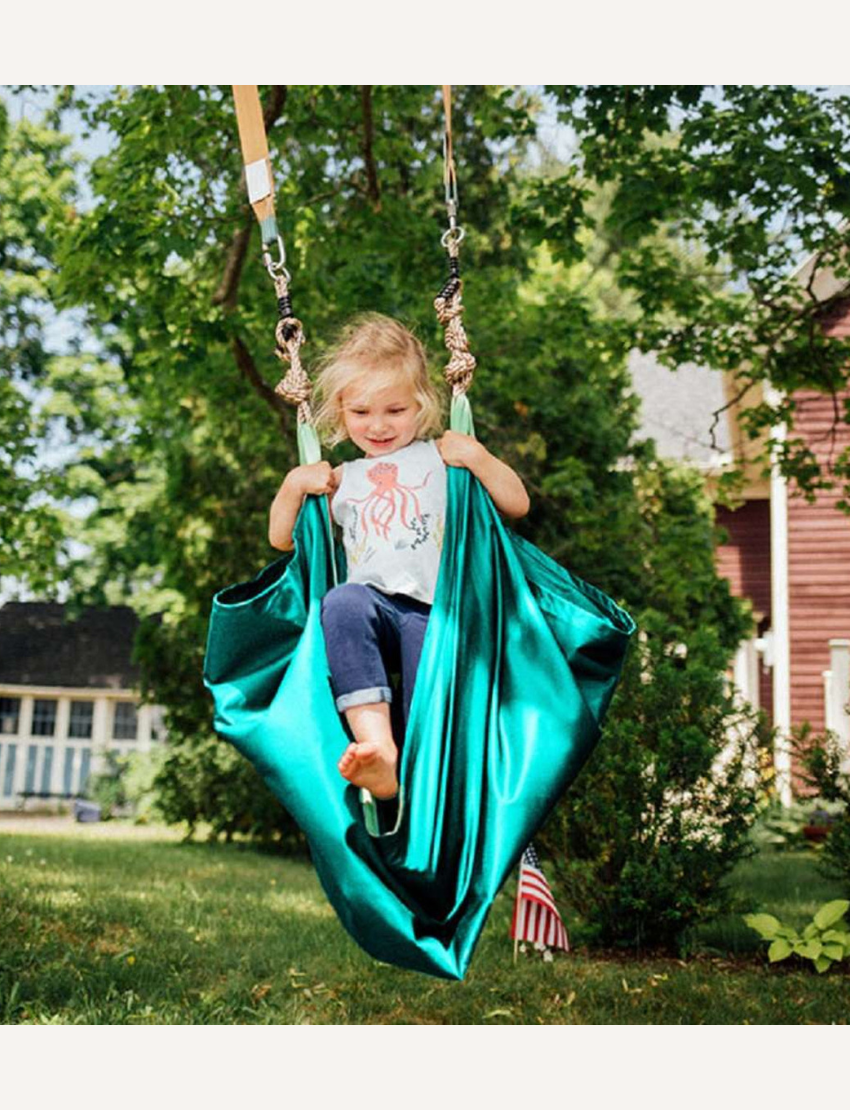 The Slackers Hammock Swing is elegantly displayed with its teal fabric and adjustable ropes. The packaging showcases backyard play and highlights the product as a "Hammock Swing" ideal for outdoor relaxation.