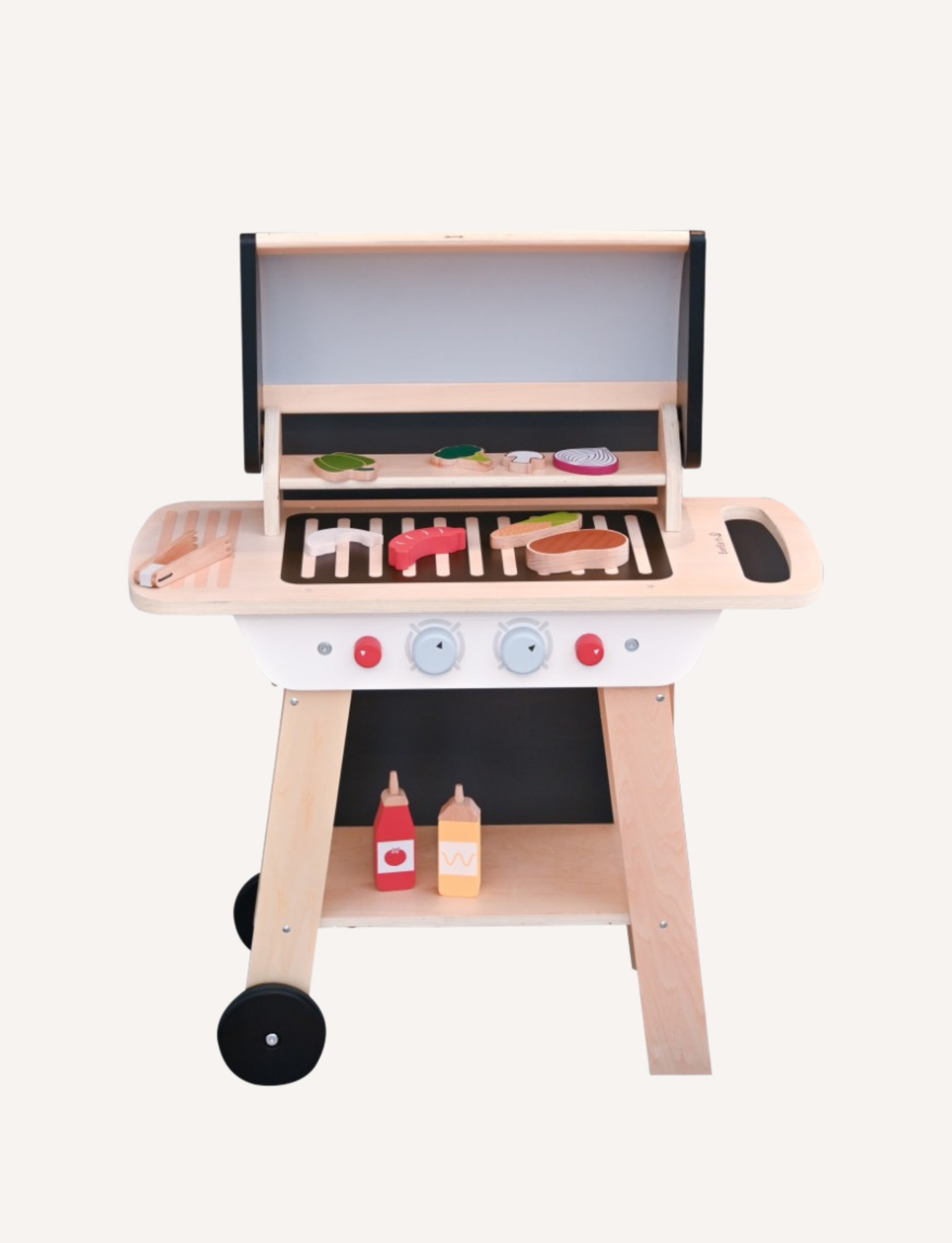 A wooden BBQ play set with a grill, wheels, and accessories like ketchup and mustard bottles, on a white background.