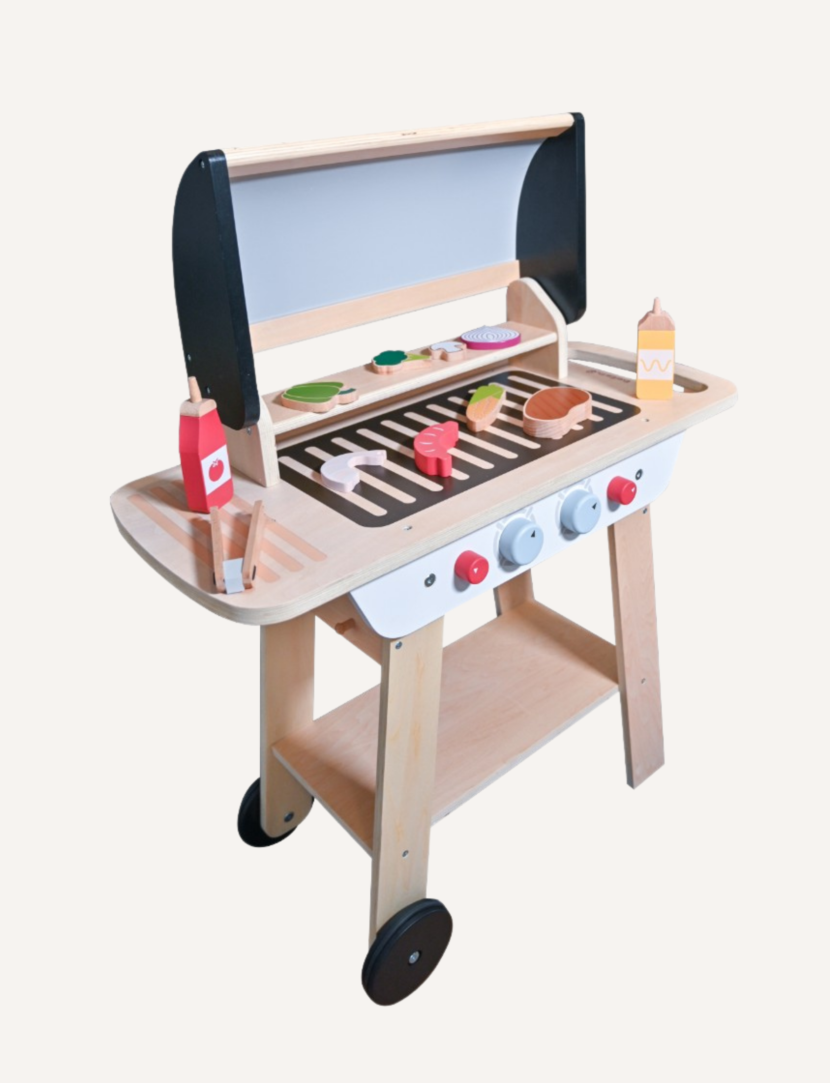 The Ever Earth BBQ Play Set with Accessories is showcased on a light background. This charming set features a grill complete with a lid, knobs, and wheels, accompanied by various wooden food items such as vegetables and meats displayed on the grilling surface. Condiment bottles and utensils are neatly arranged on the lower rack.