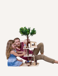 The Ever Earth Tree House is a wooden toy with three levels, featuring miniature furniture, figures, and accessories. It includes a swing on one side and a rope ladder on the opposite side. At the top, there is a small artificial tree surrounded by figures posed in various activities.