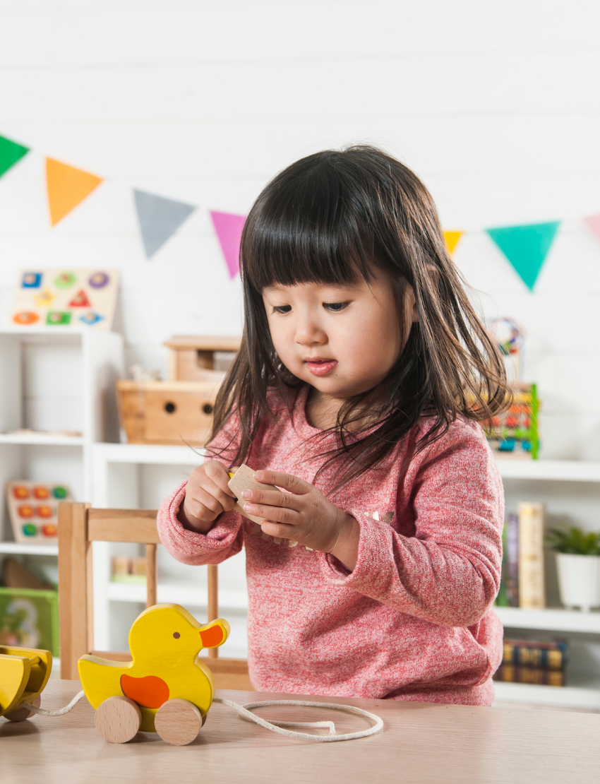 The Play Pull Along Duck & Egg by Ever Earth consists of two interlocking semi-circular pieces. One piece has a yellow disc partially concealed within a slot, while the other piece features a corresponding cut-out to accommodate the disc when assembled. The background is plain white.