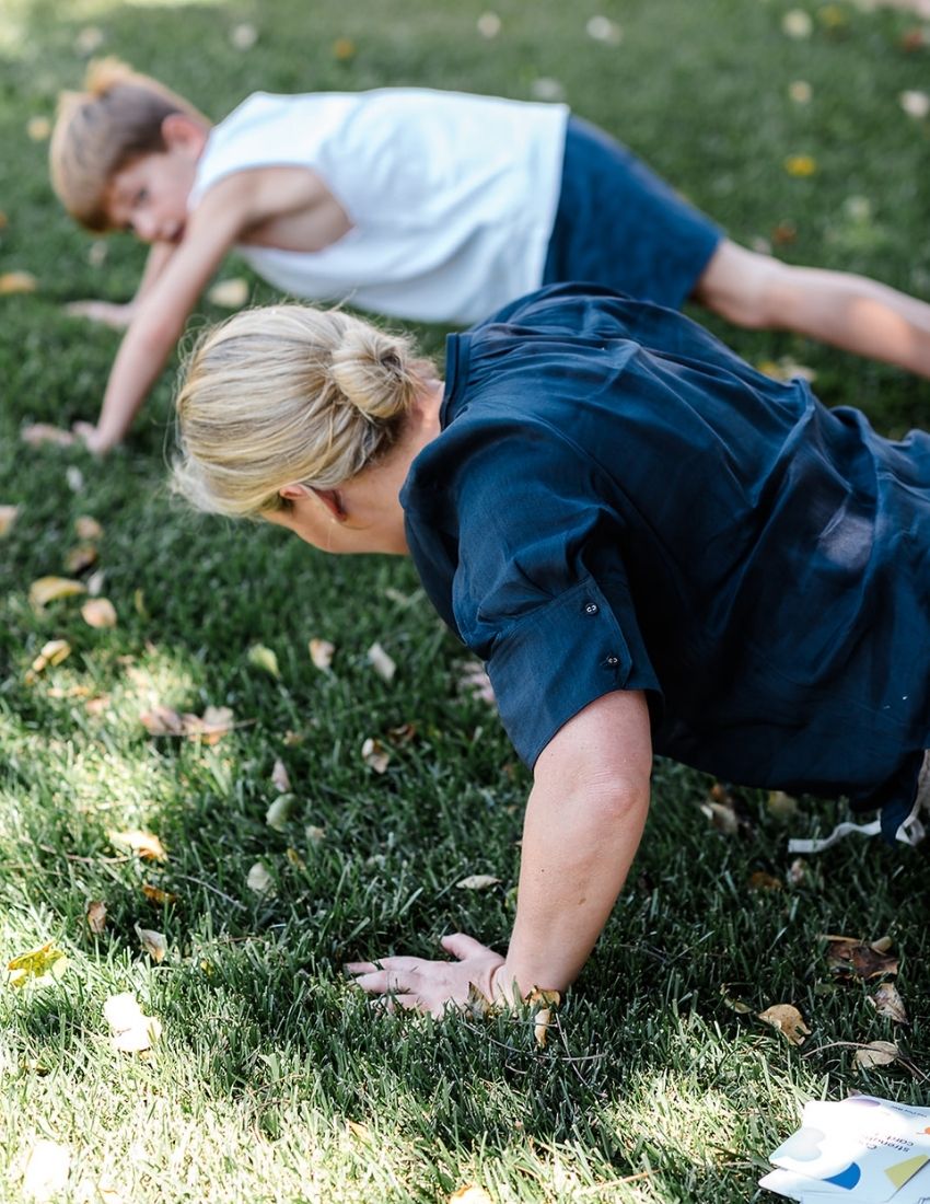 A green box is open, revealing a yellow scooter board, a silver exercise ball, and a set of purple and white "Inchworm" Core Strength Cards, all part of The Play Way's ultimate Core Strength Kit.