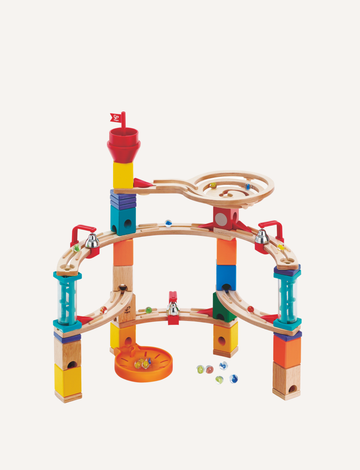 The Castle Escape by Hape is a multicolored wooden marble run set featuring a tall tower, various ramps, and a circular track at the top. Numerous marbles are scattered around the base of this STEM toy, providing both fun and educational value.