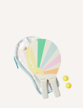 A pair of colorful, pastel rainbow-striped beach paddles with white handles, accompanied by two yellow balls, all neatly stored in a transparent carrying case with a blue zipper. This set is the Pool Side Beach Paddle Set Pastel Gelato by Sunnylife.