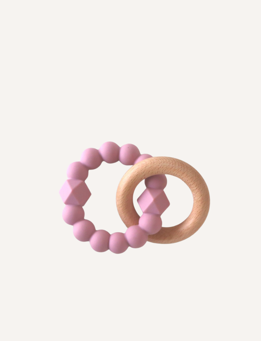 A charming Moon Teether for babies by Jellystone Designs features a beechwood teething ring connected to a second ring made up of dark gray, hexagonal, and round beads. The background is plain and light-colored.