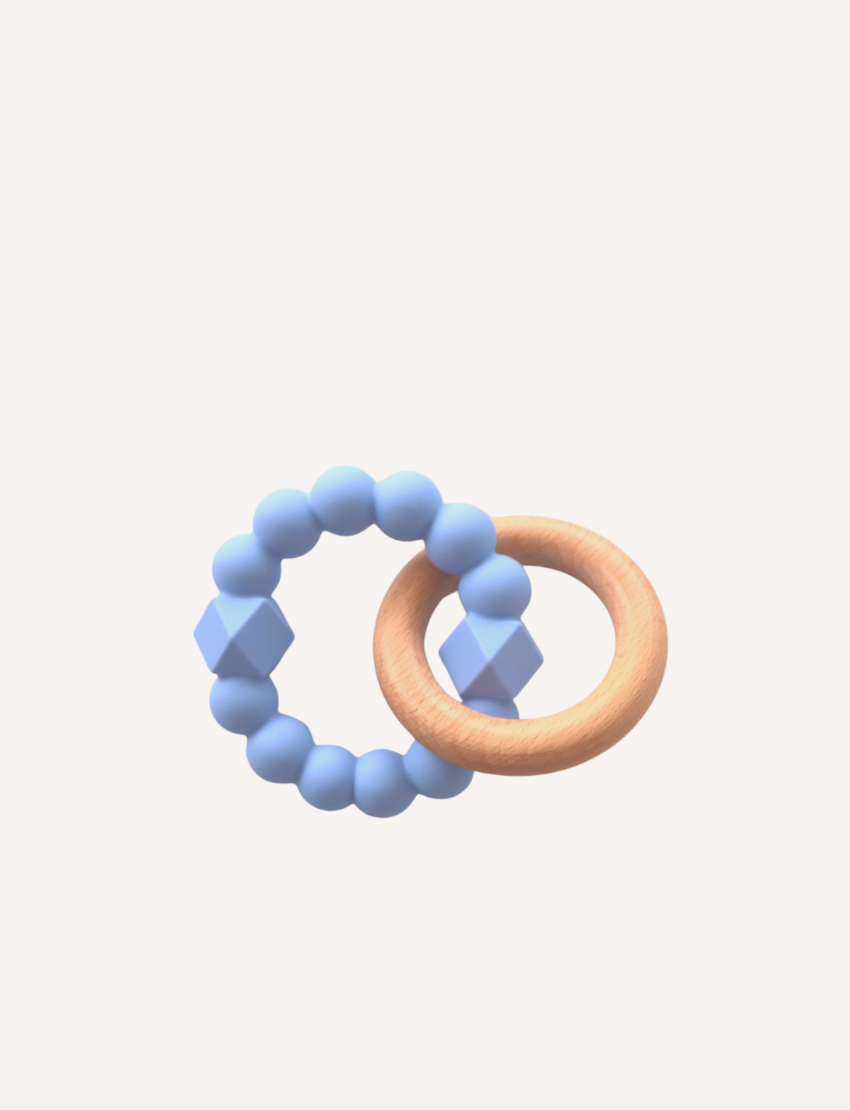 A charming Moon Teether for babies by Jellystone Designs features a beechwood teething ring connected to a second ring made up of dark gray, hexagonal, and round beads. The background is plain and light-colored.