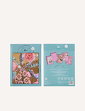 Three intricate Scratch Art greeting cards by Journey of Something, adorned with pink floral patterns, are displayed alongside two sprigs of flowers. The cards have colorful covers featuring elaborate botanical illustrations.