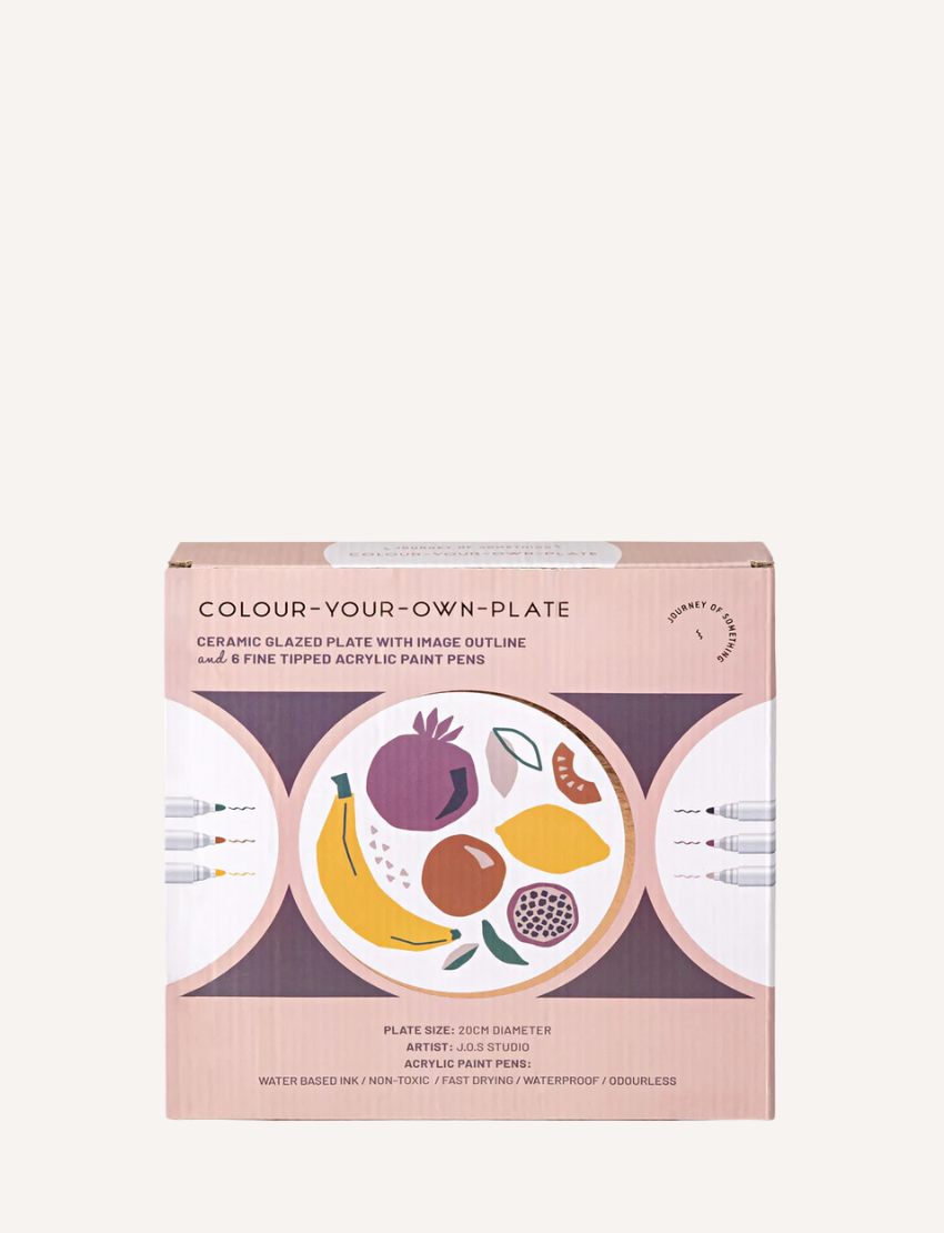 Image of the "Paint Your Own Plate - J.O.S Studio" by Journey of Something. The kit includes a plain ceramic plate with embossed leaf patterns, a set of colored markers, and a small palette. The packaging displays a partially colored plate as an example of the potential outcome.