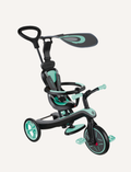 The Globber EXPLORER Trike 4-in-1 in mint features a rear handle for steering, a bucket seat with a safety bar, footrests, and a sun canopy. The tricycle has green accents and an adjustable saddle, making it perfect for young children to enjoy safe rides.