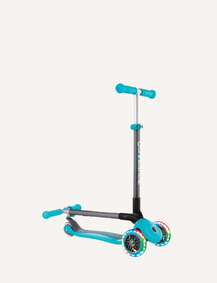 The PRIMO Foldable Lights Scooter - Teal by Globber features a turquoise and black frame, an adjustable handlebar with turquoise grips, and three wheels. The front two wheels are illuminated with colorful lights, and the deck is designed in turquoise with black accents.