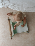 The Moover Toys Classic Baby Walker in green features a minimalistic design with 