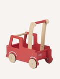 The Moover Push Truck is a red wooden toy car featuring beige wheels and handlebars. It boasts a simplistic design with cut-out windows and a small basket area at the back, marked with the word 