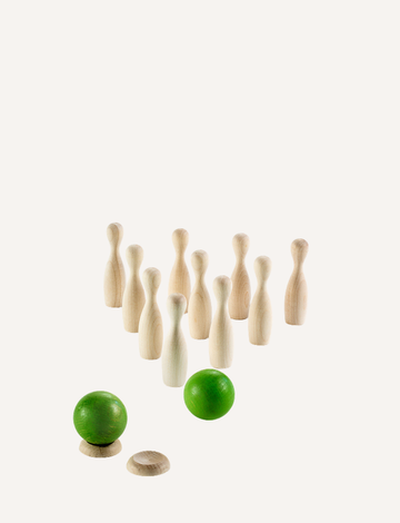 Image of a small, wooden bowling set perfect for tabletop ten-pin bowling. The Milaniwood "Green Mini Bowling" set includes ten light wooden pins arranged in a triangular formation, with two wooden balls—one green and the other light wood—in the foreground along with a small round wooden base. Ideal for family game nights.