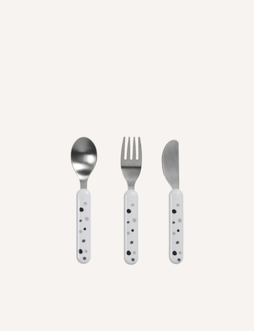 Introducing the Done by Deer Dreamy Dots Cutlery Set - White, perfect for enhancing fine motor skills during mealtime. This set of three utensils includes a spoon, a fork, and a butter knife. Each stainless steel utensil features a white plastic handle adorned with small black dots, neatly arranged on a plain white background.