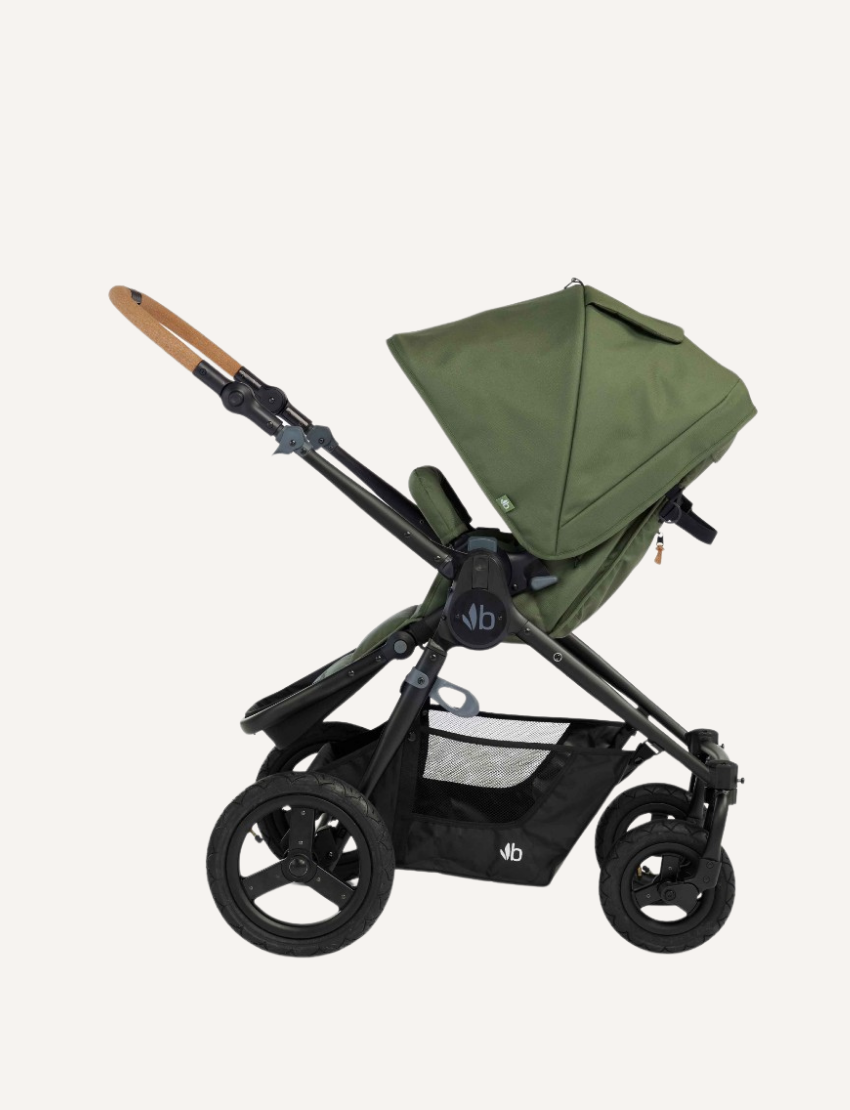 The Bumbleride ERA Pram features a green design, black frame, and brown handlebar. It offers air-filled tires with large rear and smaller front wheels for off-road use. An adjustable seat with a canopy and an under-seat storage basket complete this stroller's convenient features.