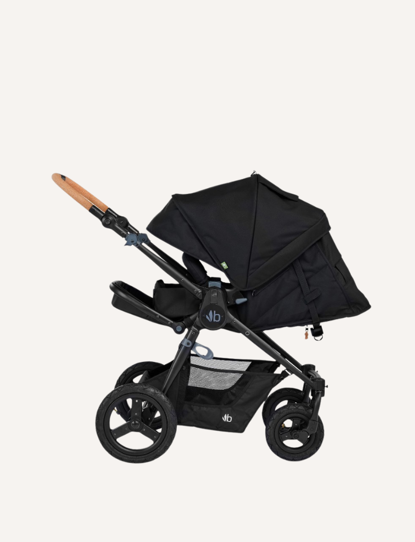 The Bumbleride ERA Pram features a green design, black frame, and brown handlebar. It offers air-filled tires with large rear and smaller front wheels for off-road use. An adjustable seat with a canopy and an under-seat storage basket complete this stroller's convenient features.