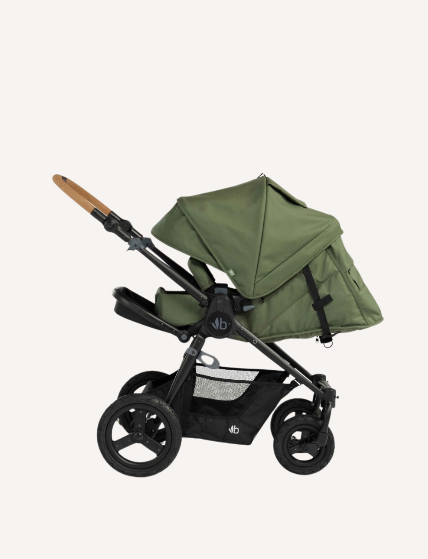 The Bumbleride ERA Pram features a green design, black frame, and brown handlebar. It offers air-filled tires with large rear and smaller front wheels for off-road use. An adjustable seat with a canopy and an under-seat storage basket complete this stroller's convenient features.