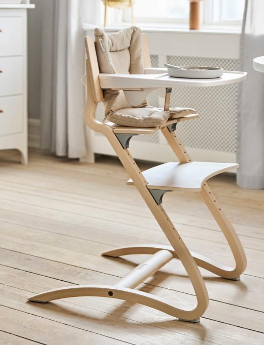 Introducing the Classic High Chair Tray by Leander: a white plastic tray showcasing a unique U-shaped design with a slightly raised edge, crafted for easy placement over surfaces such as chairs. The backdrop is simple and light-colored.