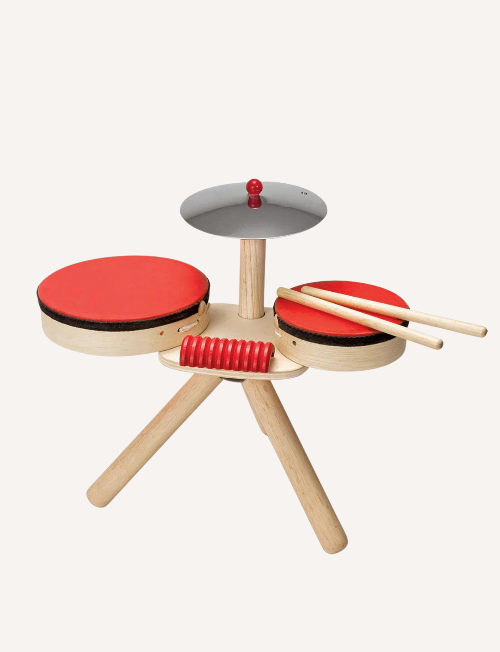 The PlanToys Musical Band is a small wooden drum set with three legs, perfect as a toddlers' musical toy. It includes two red drums, a metallic cymbal with a red bead on top, and two wooden drumsticks. The overall design is simple, minimalist, and eco-friendly.