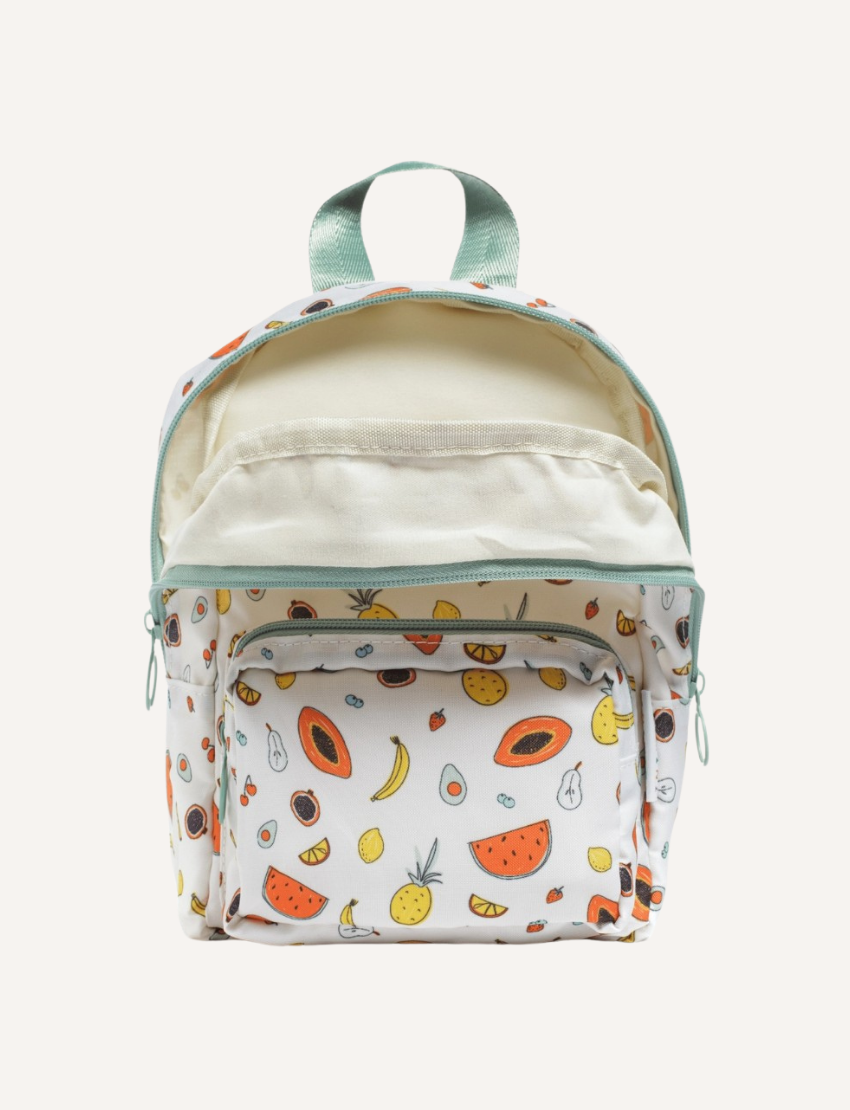 The IZIMINI Mini Backpack, featuring a cream-colored base adorned with a playful fruit pattern—including avocados, bananas, pineapples, and watermelons—is perfect for your toddler. It boasts mint-green straps and zipper pulls, a small exterior pocket, and plenty of space for little essentials.