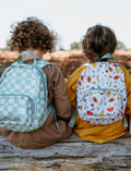 The IZIMINI Mini Backpack, featuring a cream-colored base adorned with a playful fruit pattern—including avocados, bananas, pineapples, and watermelons—is perfect for your toddler. It boasts mint-green straps and zipper pulls, a small exterior pocket, and plenty of space for little essentials.