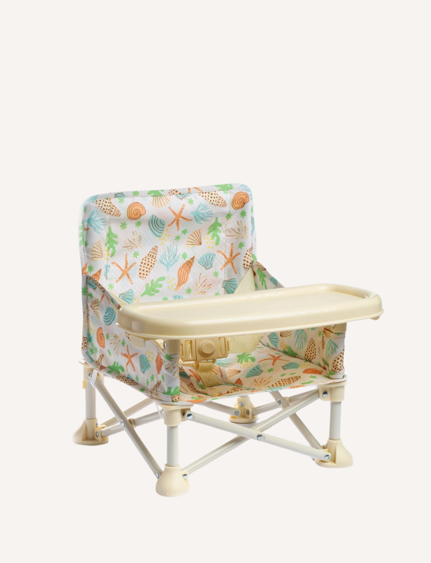 The IZIMINI Baby Chair is a lightweight and portable option, featuring a pink and white checkered fabric seat and a beige tray. It boasts a durable frame made of white plastic and metal, with secure, wide-set feet for enhanced stability.