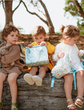 The IZIMINI Sailor Lunch Bag is a rectangular insulated lunch bag featuring a white background adorned with a colorful seashell pattern. It boasts a turquoise zipper and matching handles, and has a structured shape that stands upright.