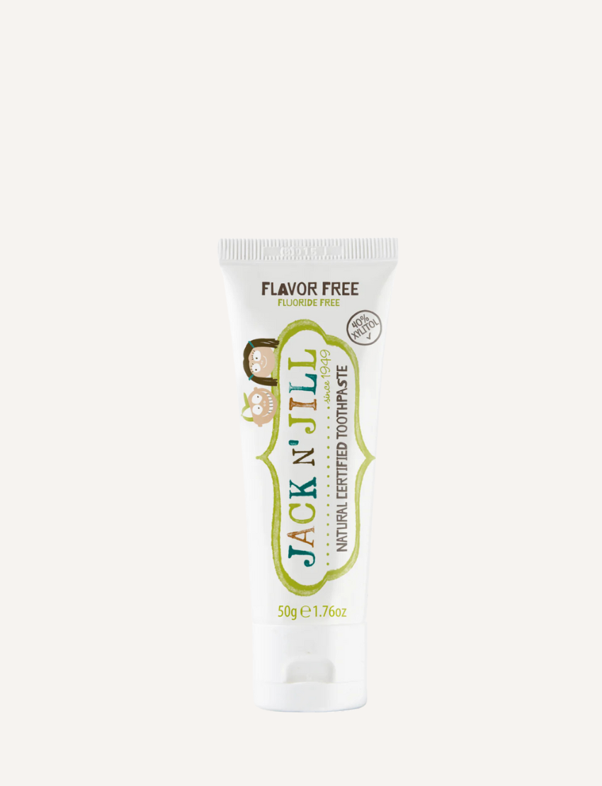 A white tube of Jack N' Jill Flavour Free Natural Toothpaste is displayed against a plain background. The tube, labeled as flavor-free, fluoride-free, and weighing 50g (1.76 oz), features illustrations of children.